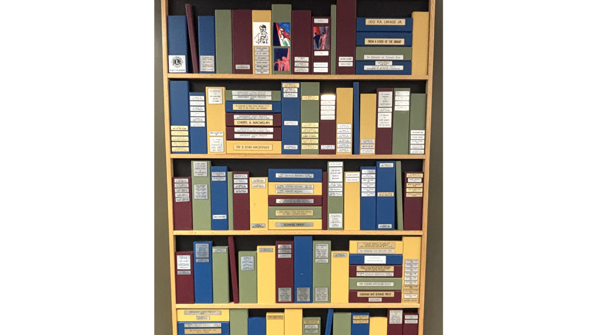 Image of a donor recognition wall showing multi-coloured spines of wooden books with silver and gold plaques on them